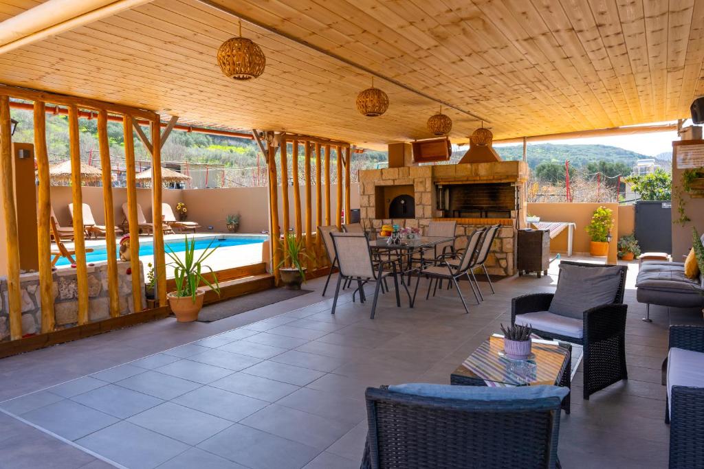 a patio with a table and chairs and a pool at Countryhouse Villa with pool & private parking in Heraklio Town