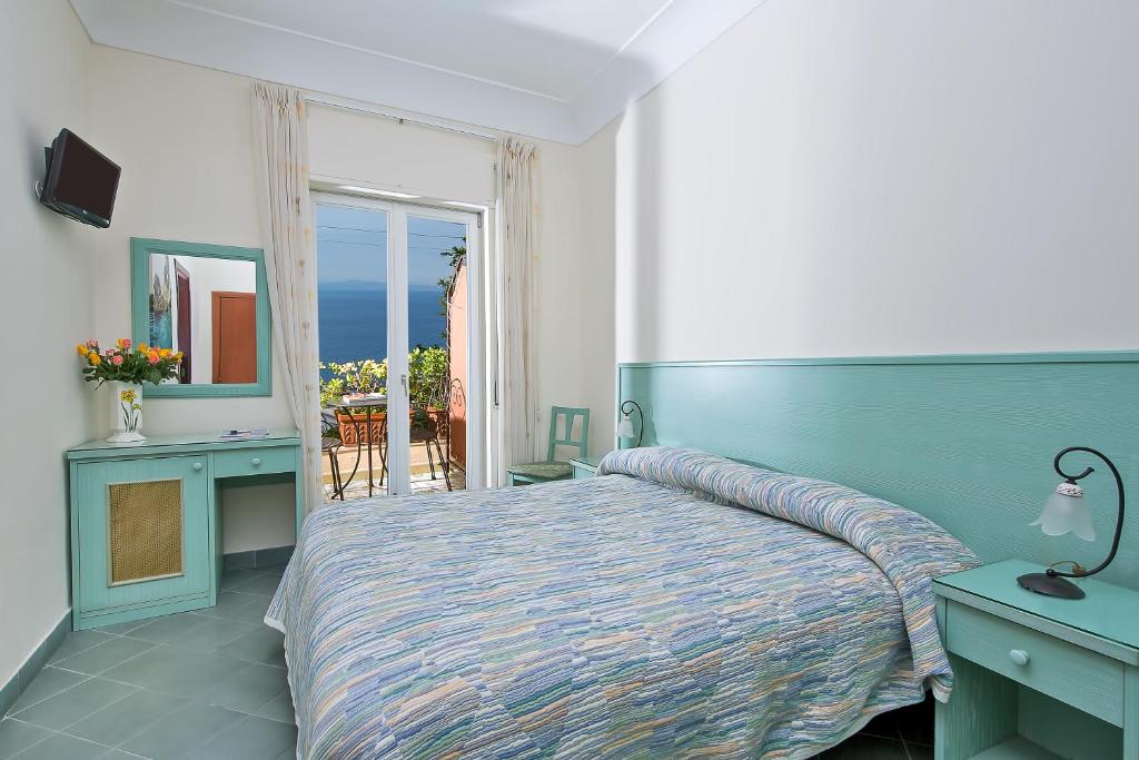 a bedroom with a bed and a view of the ocean at Da Giorgio in Capri