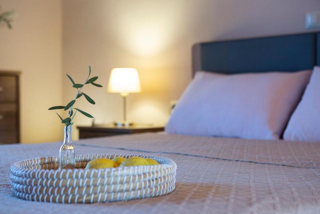 a bowl of fruit on a bed with a plate of fruit at Lemon House Lefkada in Lefkada