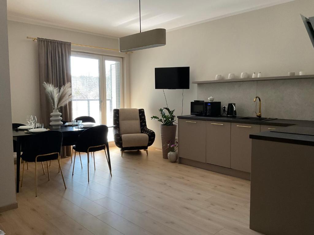 a kitchen and living room with a table and chairs at Apartament ELEGANCE in Zamość