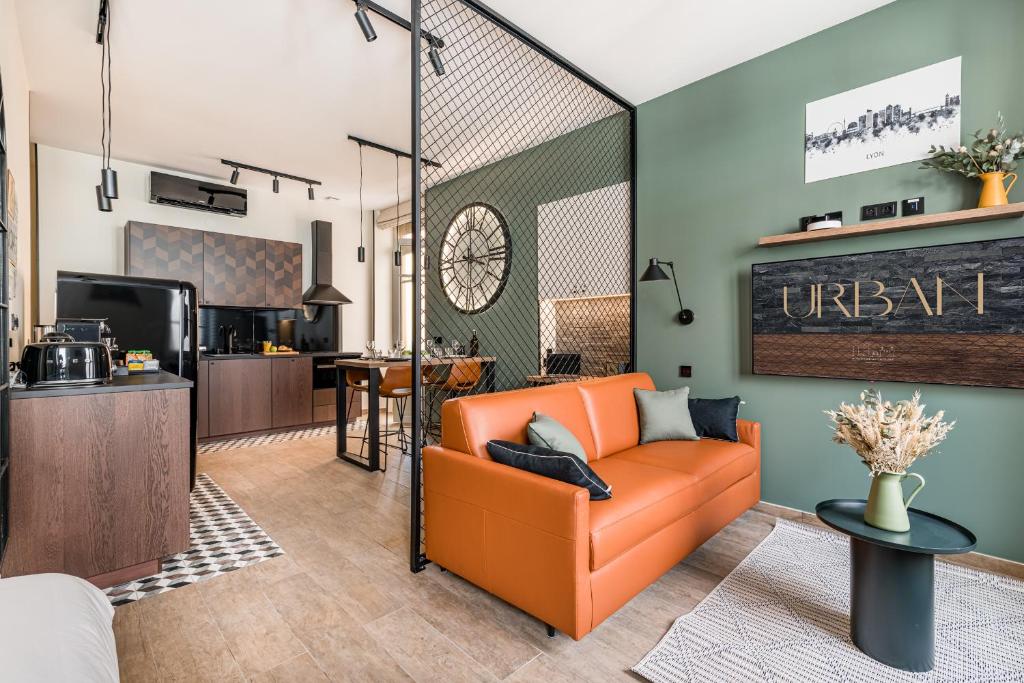 un salon avec un canapé orange et une cuisine dans l'établissement Urban - Lyon PartDieu, à Lyon