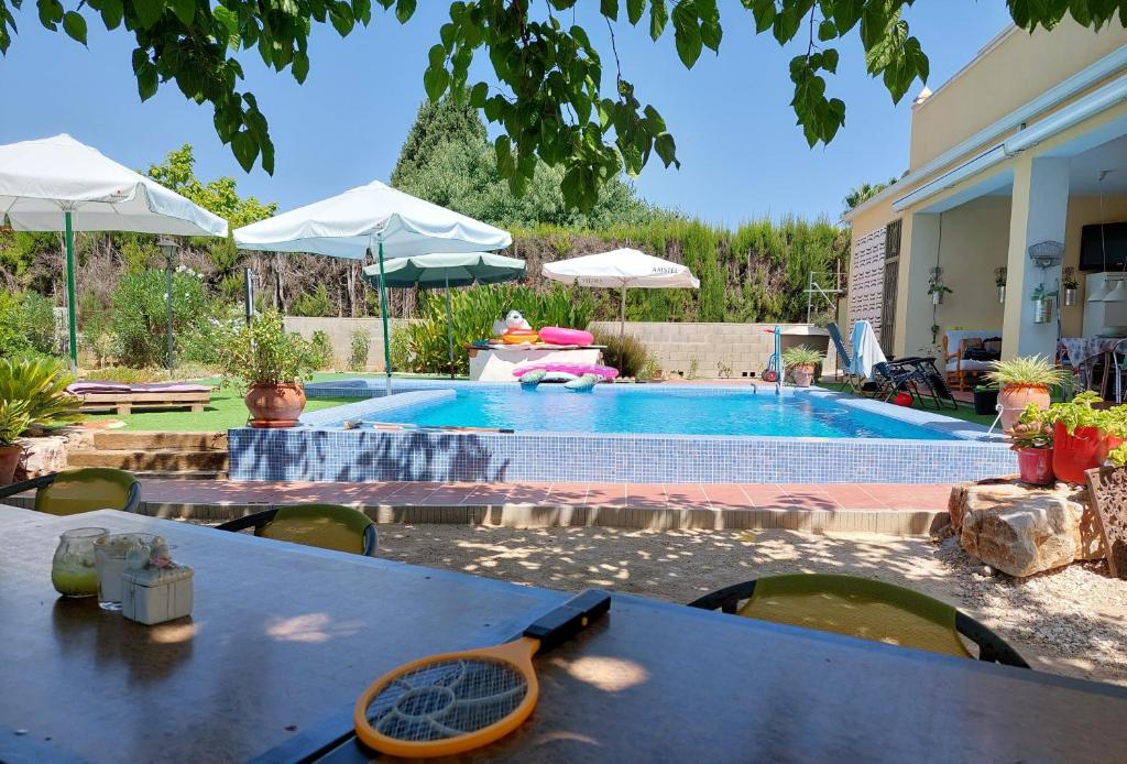 a pool with a table and chairs next to a house at Appartement La Ponça in Ontinyent