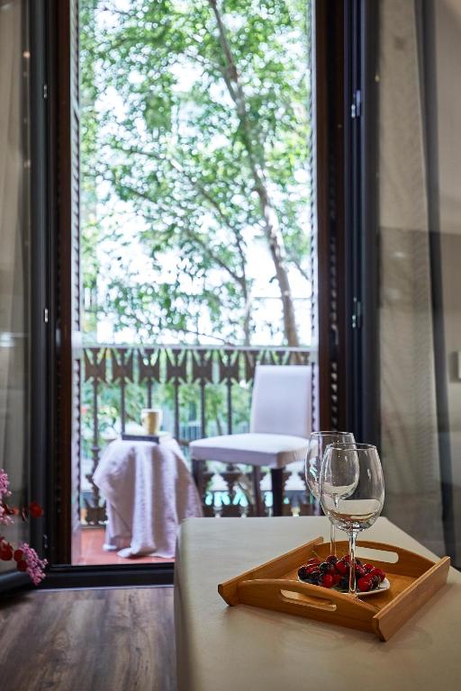 a glass of wine sitting on a table with a window at BBarcelona Rogent Flats in Barcelona