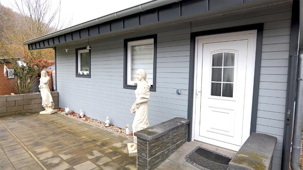 two statues of people standing outside of a house at Chalet 1022 in Nideggen
