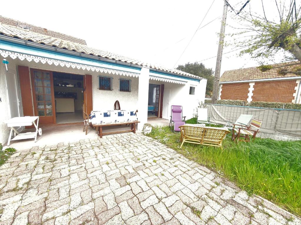 une cour avec une table de ping-pong et des chaises dans l'établissement villa au coeur de soulac, à Soulac-sur-Mer