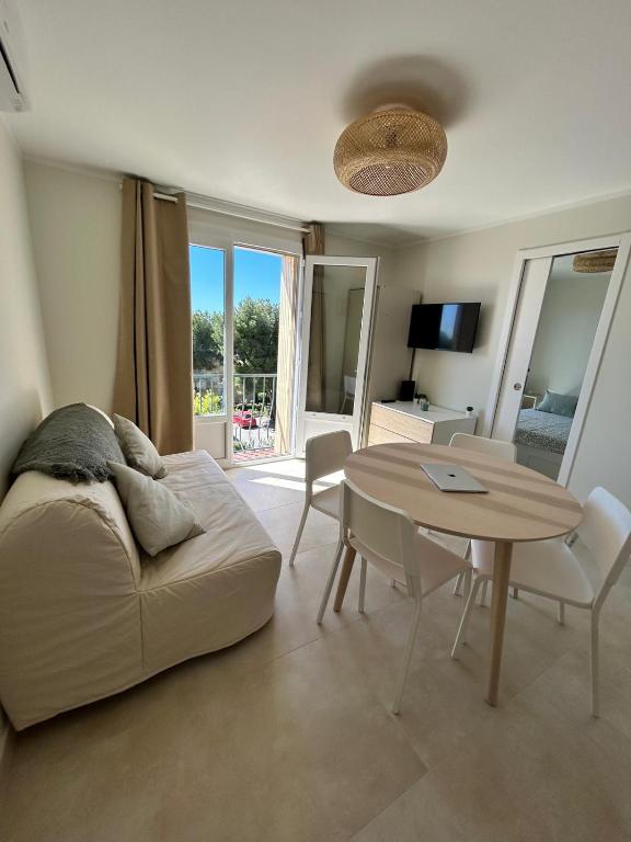 un salon avec un lit et une table dans l'établissement Le Cocon des Floréal, à Bandol