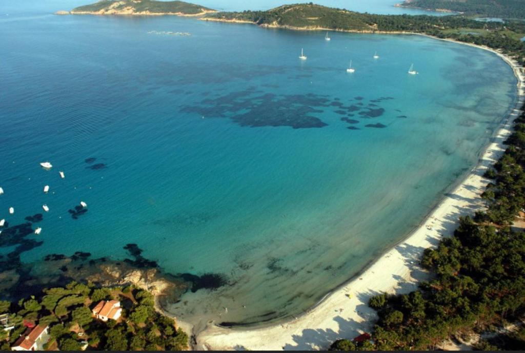 une vue aérienne d'une plage avec des bateaux dans l'eau dans l'établissement Mini Villa à 3 minutes de la plage de Pinarello, à Pinarellu