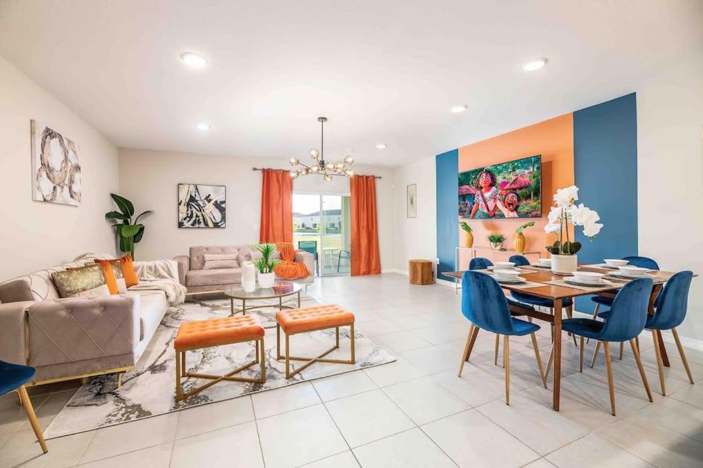 Designer Decorated - 3 Bedroom NEAR DISNEY في كيسيمي: غرفة معيشة مع طاولة وكراسي زرقاء