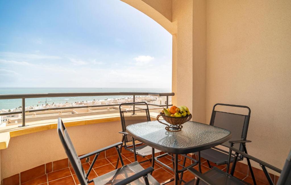Una mesa y sillas en un balcón con vista a la playa. en Cozy Apartment In Carboneras, en Carboneras