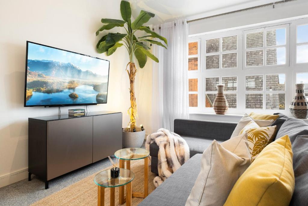 a living room with a couch and a flat screen tv at The Palm- City Centre 2 Bed, Sleeps 7, Netflix in Leicester