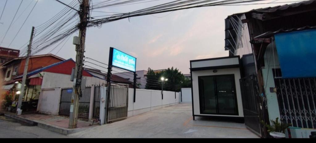 an empty street next to a building with a sign at บ้านใต้ชุกโดน BaantaiChukadon guest house in Kanchanaburi City