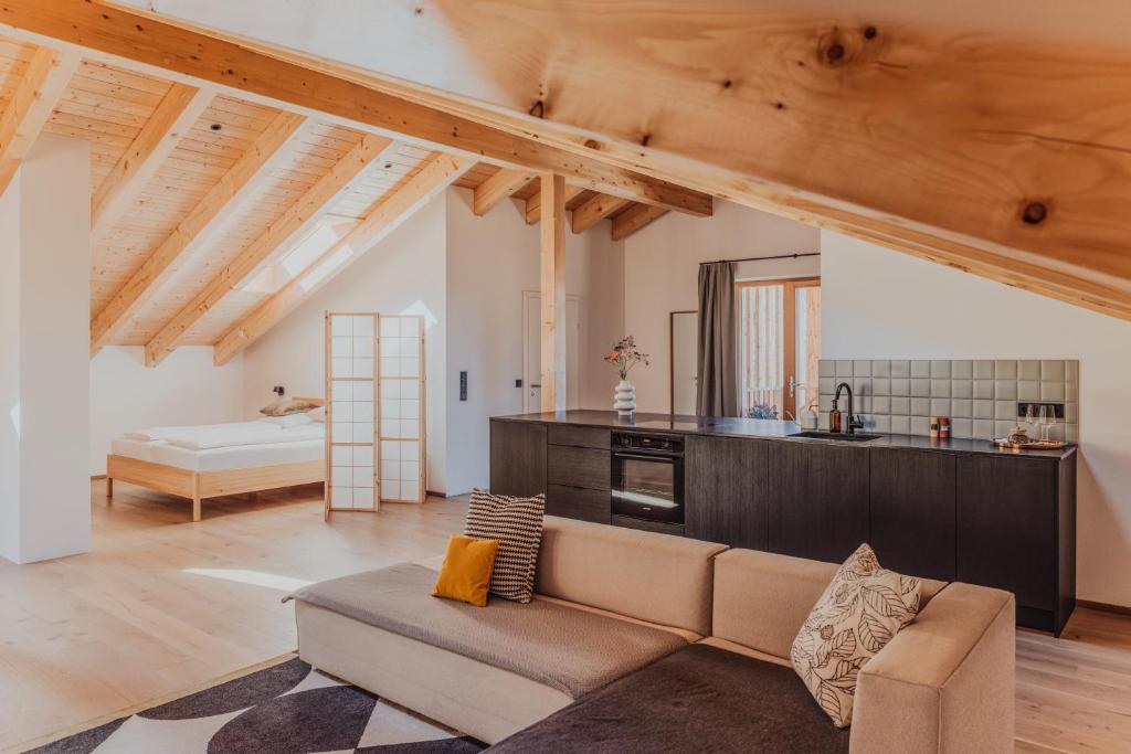 a living room with a couch and a kitchen at Hofstatt Salzburg - Ferienwohnung in Söllheim