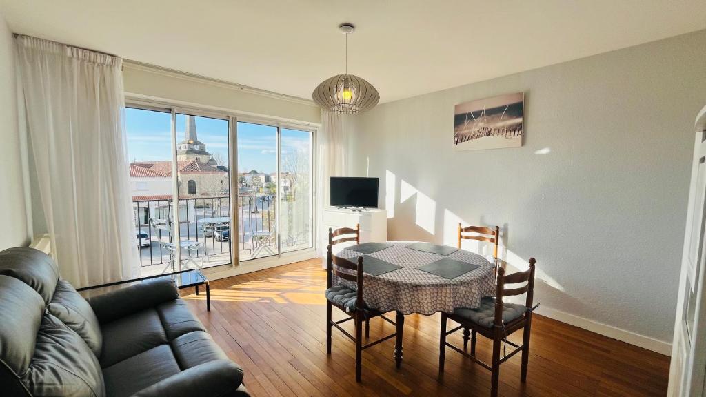 un salon avec une table et un canapé dans l'établissement Le Centre Bourg, situation rêvée, à Saint-Jean-de-Monts