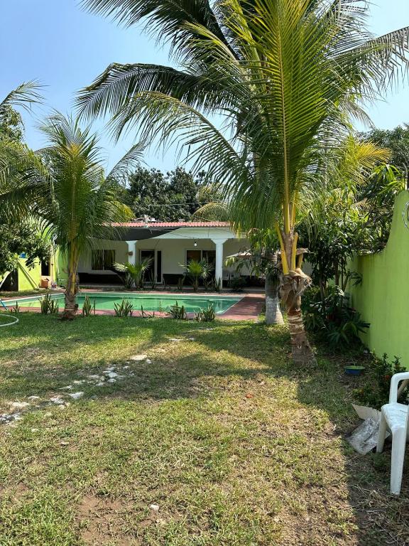 a house with a palm tree and a swimming pool at Chalet brisas del mar in Chiquimulilla