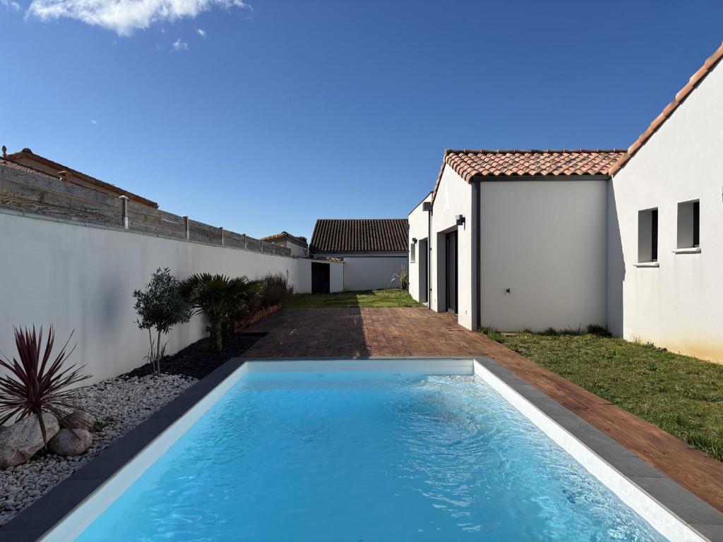 une piscine dans l'arrière-cour d'une maison dans l'établissement Villa avec piscine 6 personnes, à Château-dʼOlonne