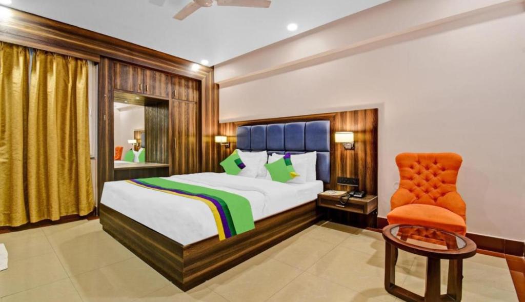 范兰德凡Hotel Light House Urban Silverkey -Free unlimited 5g internet, in house parking- Fully AC - Near Prem Mandir的一间卧室配有一张床和一张橙色椅子