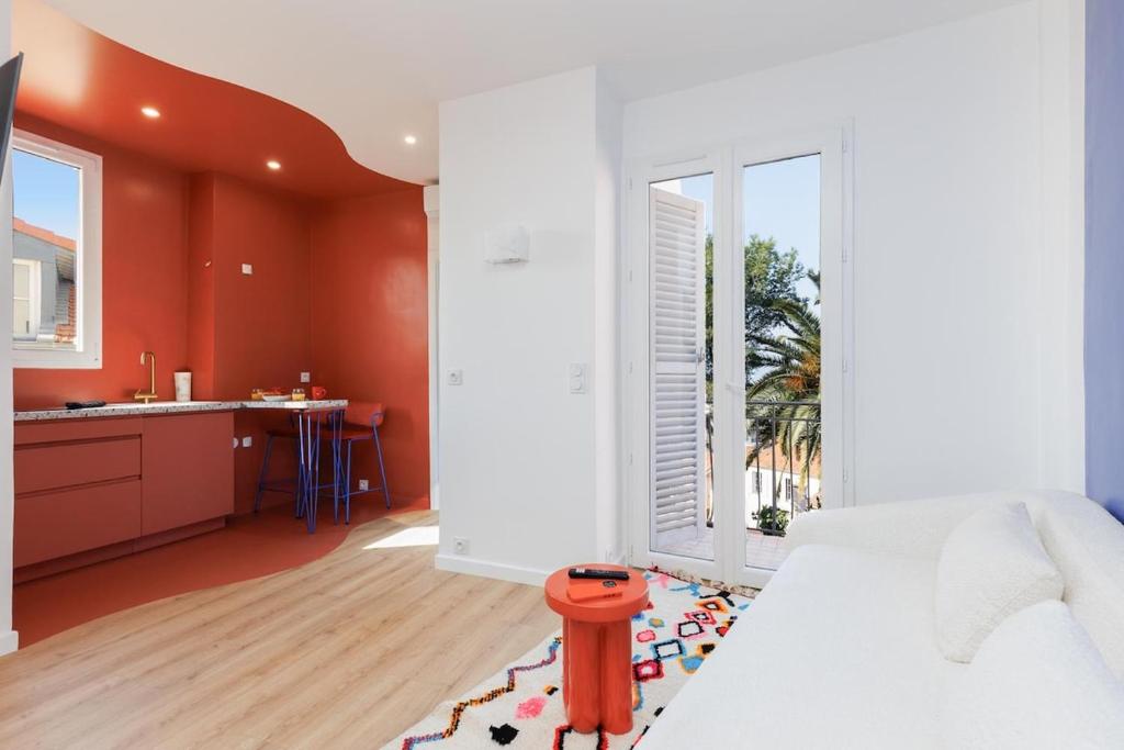 Cet appartement comprend une chambre avec des murs orange, un lit et une cuisine. dans l'établissement 