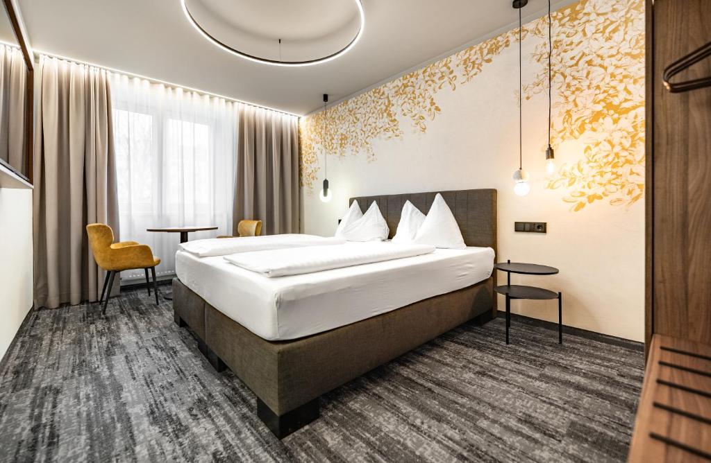 a hotel room with a bed and two tables at Hotel Lokomotive in Linz