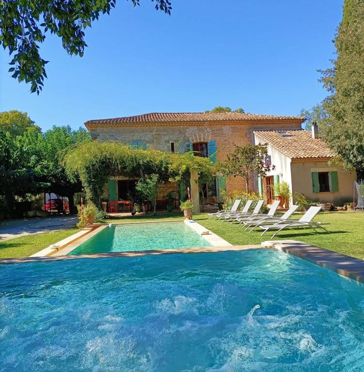une maison avec une piscine en face d'une cour dans l'établissement Mas Le Clos de Teillan 6 chambres 3 SDB, Piscine, Sauna, Bain à remous, à Aimargues
