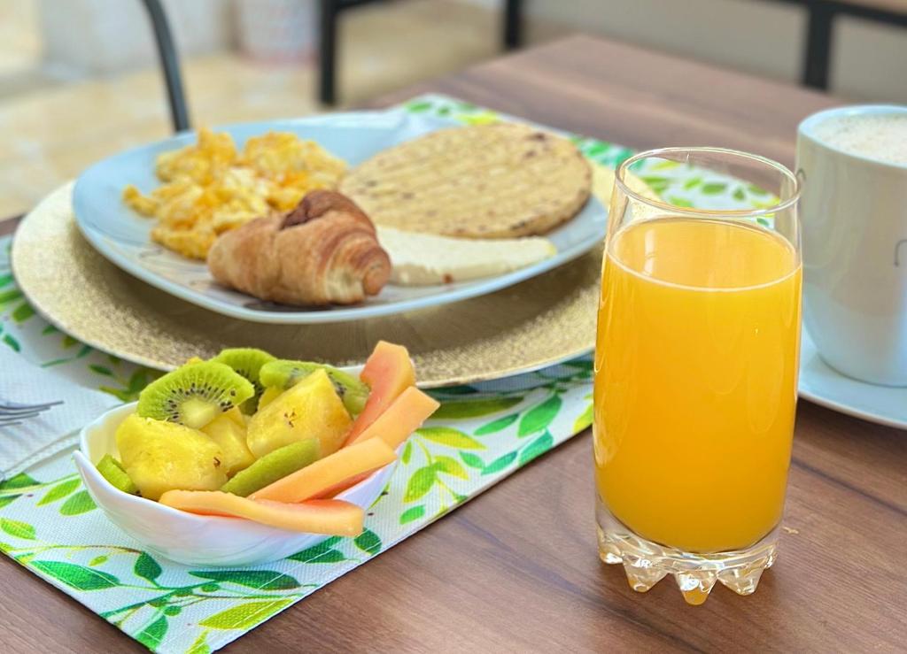 a table with a plate of food and a glass of orange juice at Encanto 3 in Santa Rosa de Cabal