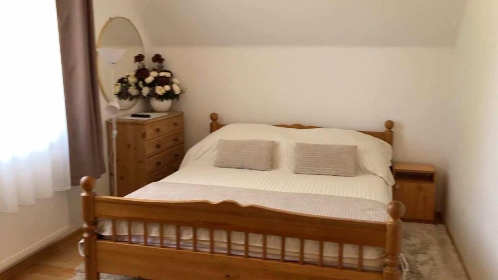 sypialnia z łóżkiem, komodą i lustrem w obiekcie Rita-Vár Szálláshely w Nyíregyházie
