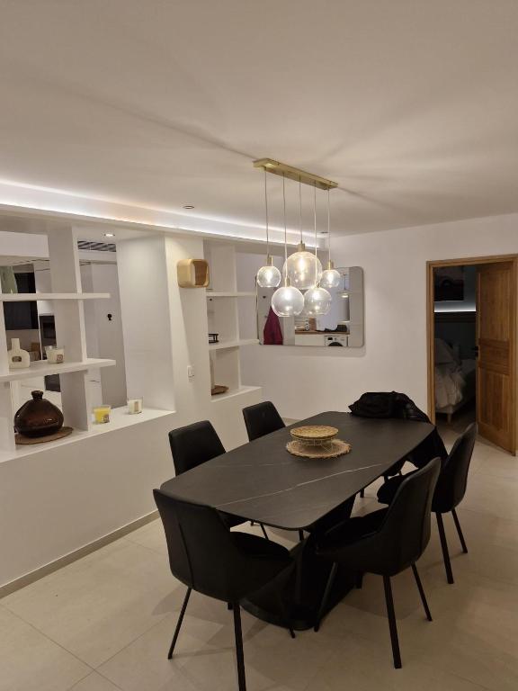 a dining room with a black table and chairs at Appart deux suites st tropez in Saint-Tropez