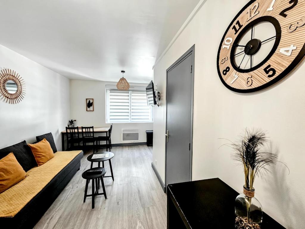 - un salon avec une grande horloge murale dans l'établissement Evasion, Appartement avec terrasse, à Reims