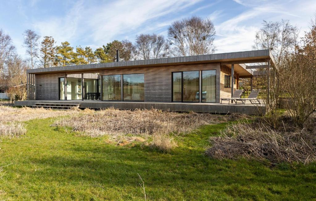 a modern house on a hill with a grass field at Lovely Home In Ebeltoft With Wifi in Ebeltoft