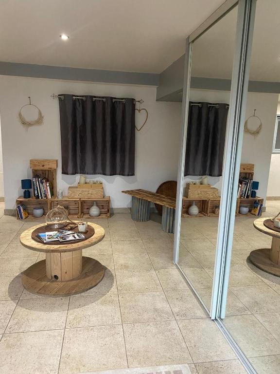 - un salon avec une table et un miroir dans l'établissement Maison chaleureuse, à Matemale