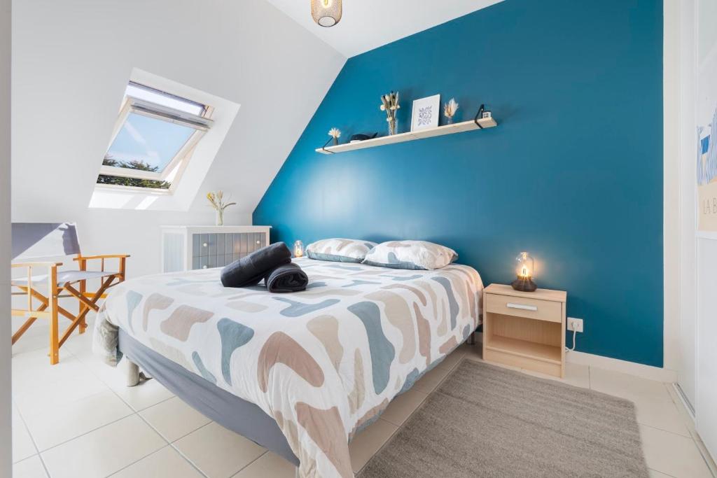 une chambre avec un lit avec un mur bleu dans l'établissement Séjour Confort Mer & Littoral LE CROISIC, au Croisic
