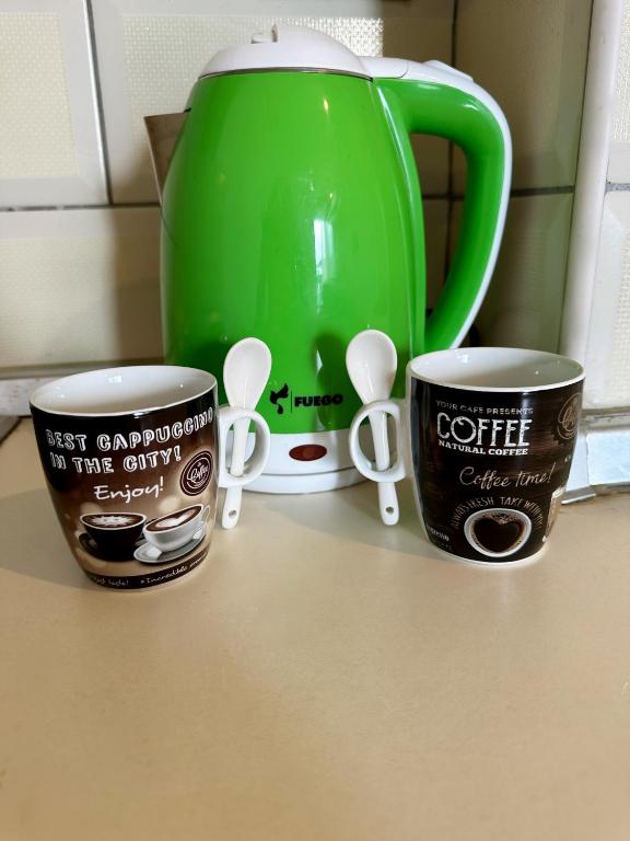 due tazze di caffè appoggiate su un bancone accanto a una teiera di Easy stay a Kashari