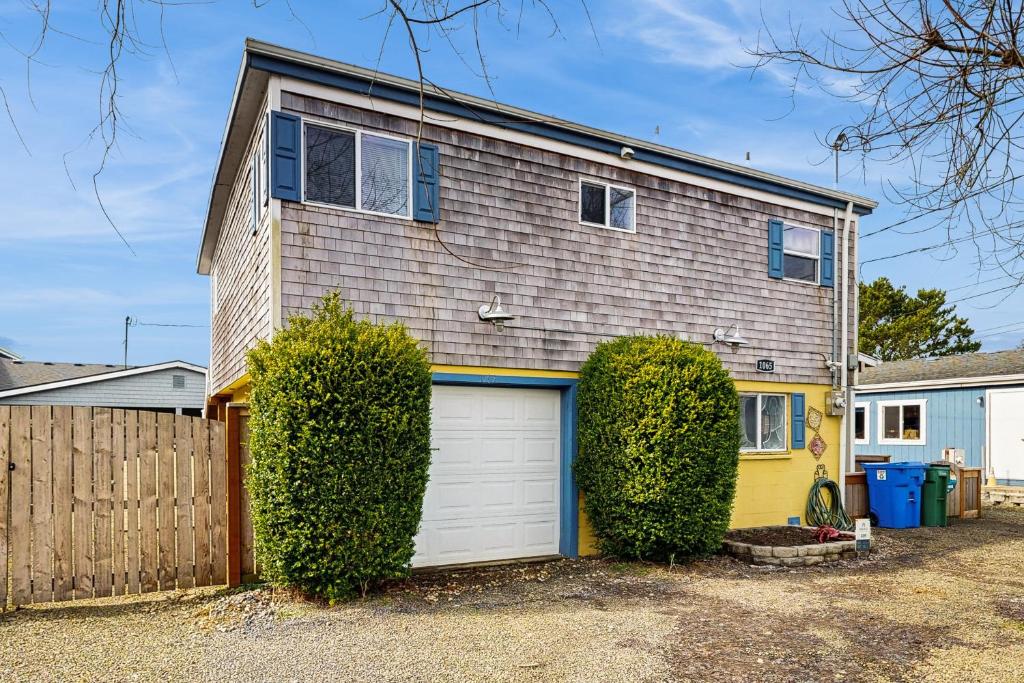 a house with a garage and a fence at The Sandbox at Rockaway Beach in Rockaway Beach