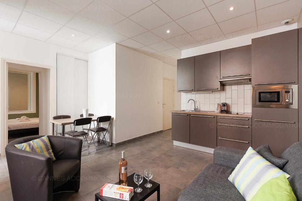 un salon avec un canapé et une cuisine dans l'établissement Residence Aout 22, à Cannes