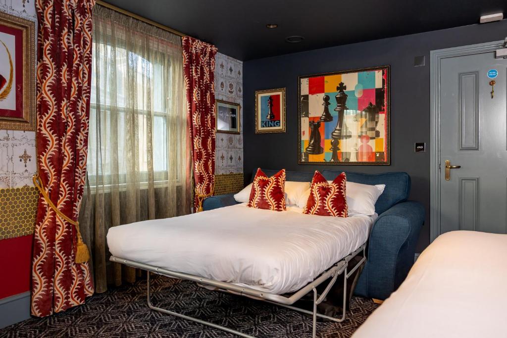een slaapkamer met een bed met rode kussens bij The Kings Arms Pub & Boutique Rooms in Londen