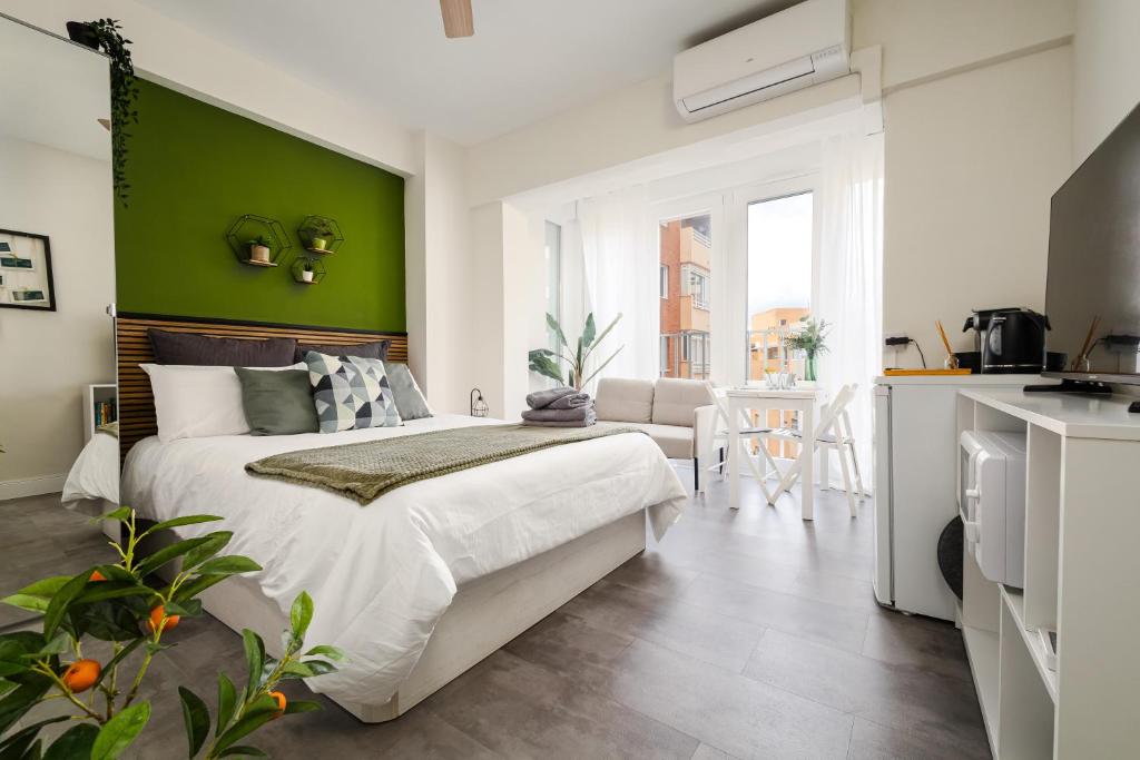 sypialnia z dużym łóżkiem i zieloną ścianą w obiekcie Beach Studio Apartment Playa Malagueta w Maladze