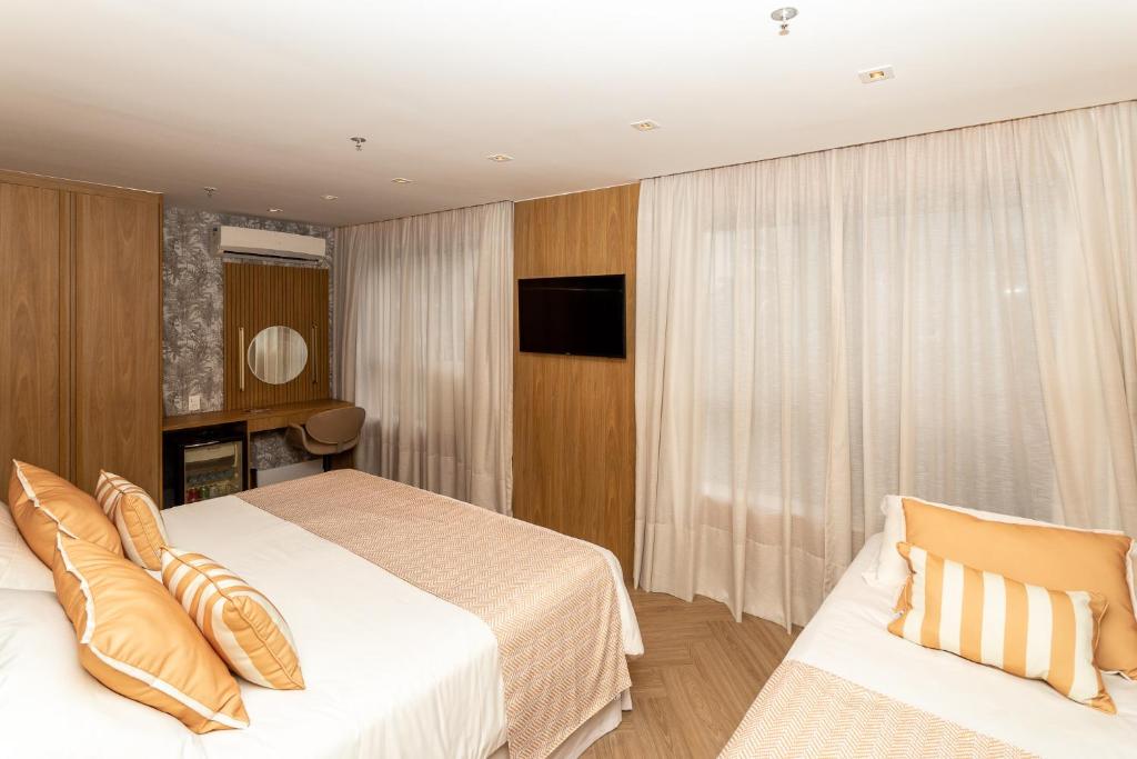 a hotel room with a bed and a television at Mar Ipanema Hotel in Rio de Janeiro