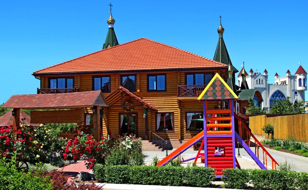 uma casa com um parque infantil em frente a uma casa em Комплекс отдыха Пампушка & Подушка em Odessa