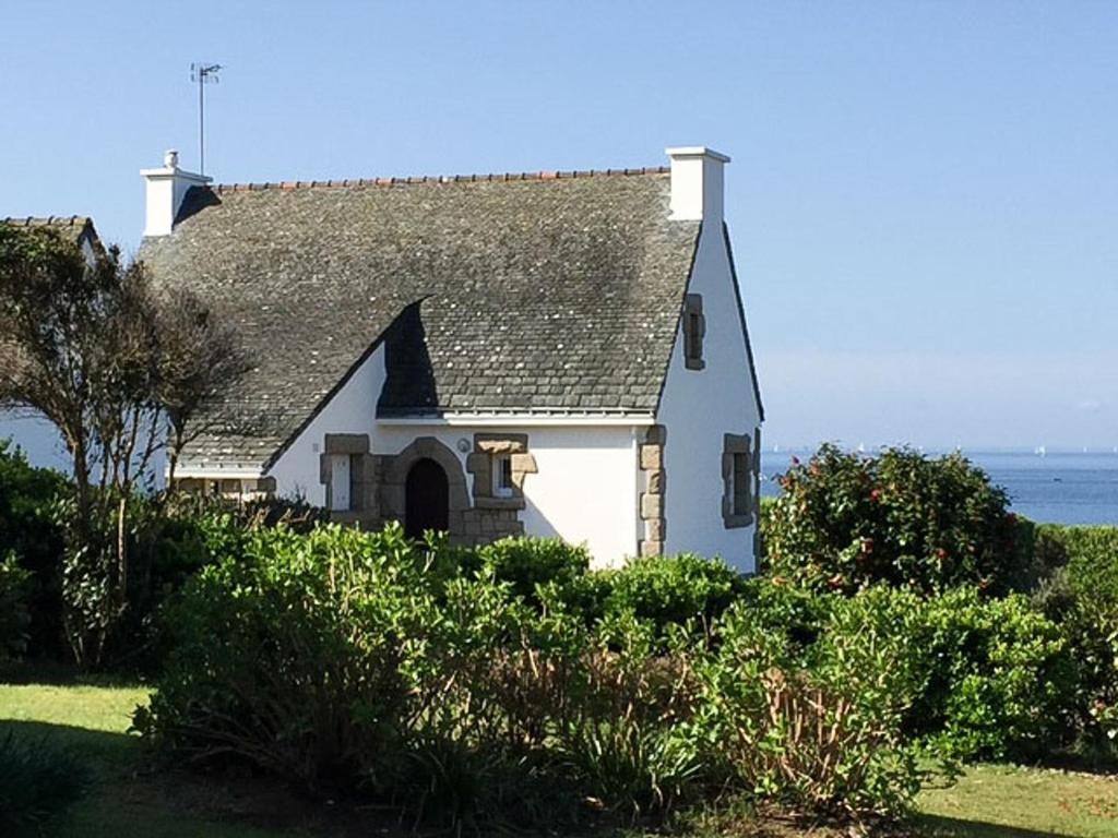 une maison blanche avec un toit gris et l'océan dans l'établissement Charmante Maison Familiale avec Vue Mer à Port Navalo - 8 personnes - FR-1-639-137, à Arzon