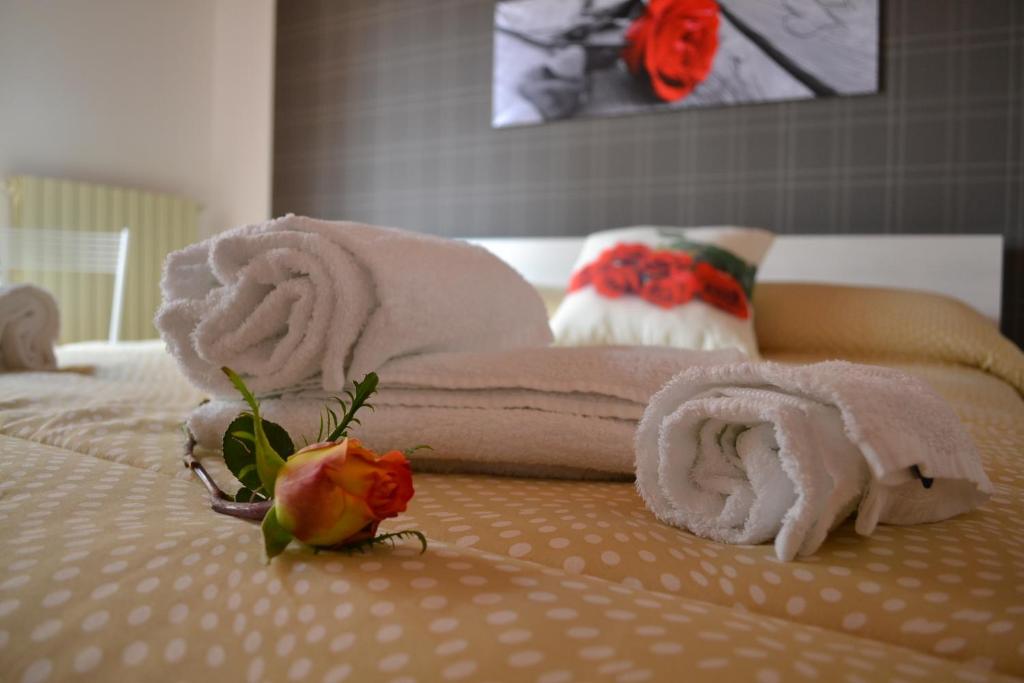 un letto con asciugamani e una rosa sopra di Le Rose di Modica a Modica