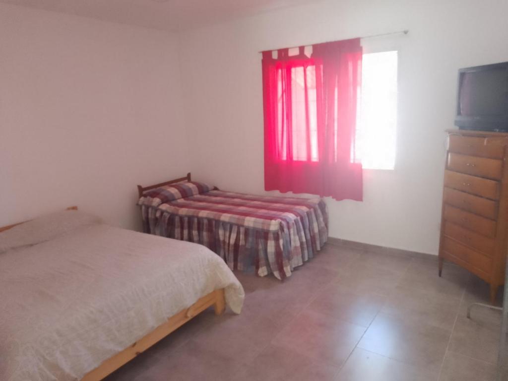 a bedroom with a bed and a window and a tv at CaSa VALENTINA in San Clemente del Tuyú