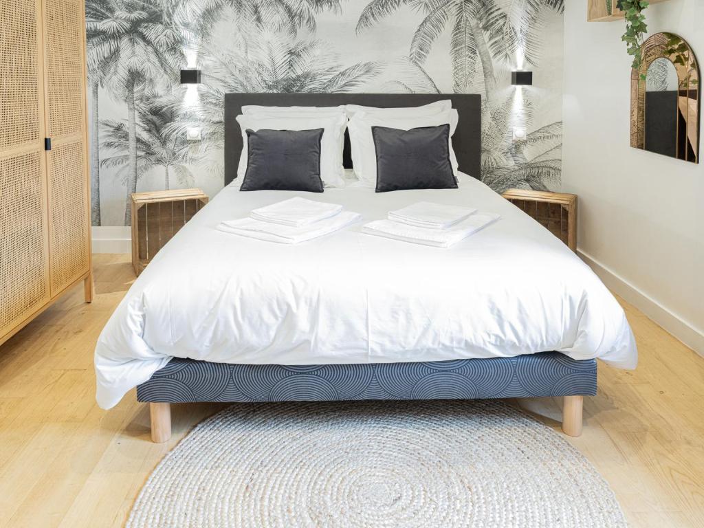 une chambre avec un grand lit avec des draps et des oreillers blancs dans l'établissement La Boca Noche Chambres d'Hotes et Gite, à Saint-Antonin