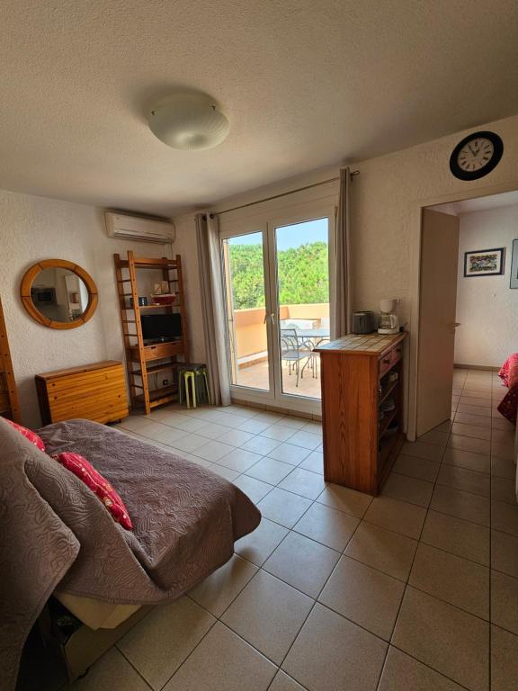 une chambre avec un lit et une vue sur un balcon dans l'établissement Charmant T2 climatisé avec terrasse - 200 m de la plage - les Boramars, à Argelès-sur-Mer