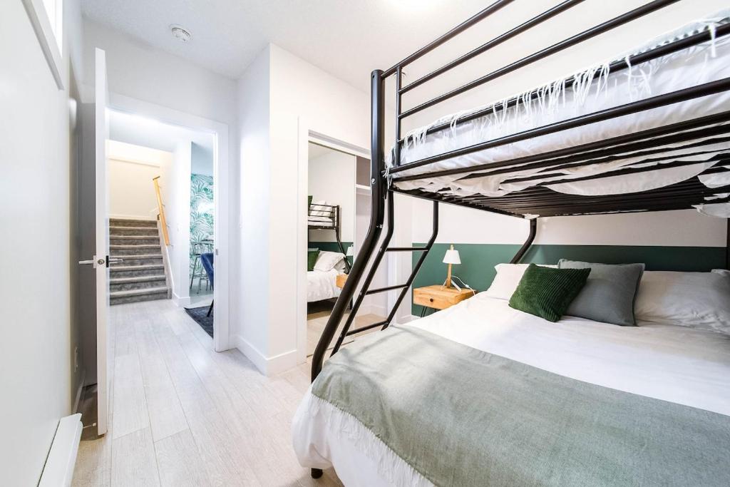a bedroom with a bunk bed and a staircase at 5BR-Luxury Retreat-Hot Tub-King Bed-Rogers Place-DT in Edmonton