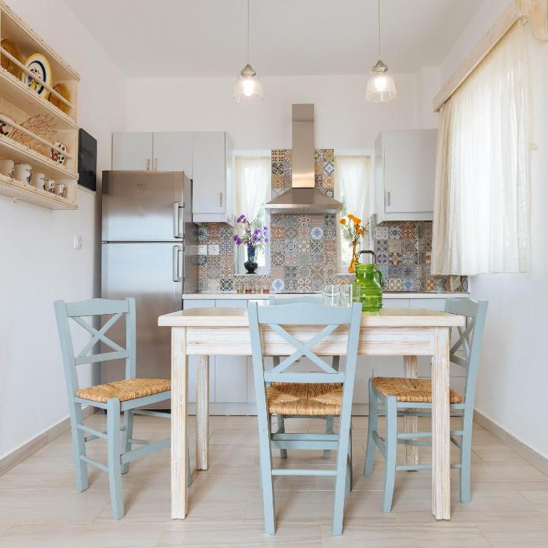 a kitchen with a table and chairs and a refrigerator at Silene Villas in Amoopi