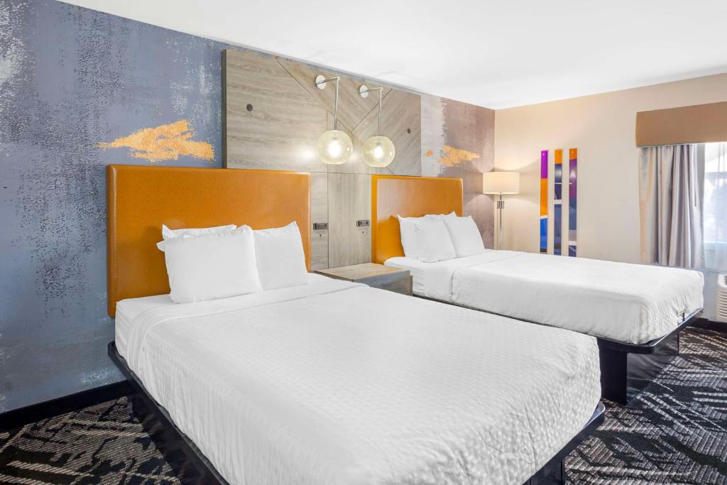 two beds in a hotel room with white sheets at Best Western Chambersburg in Chambersburg