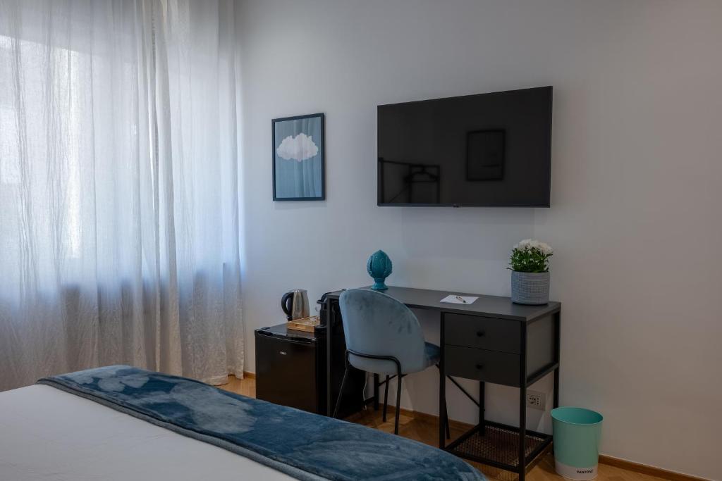 a bedroom with a desk and a bed and a chair at Cosy in Bari