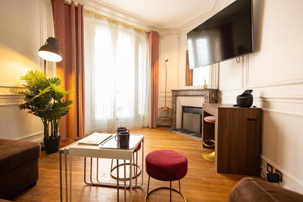 a living room with a couch and a table at Le Montrouge BEL APPARTEMENT CONFORT GLAM CHIC in Montrouge