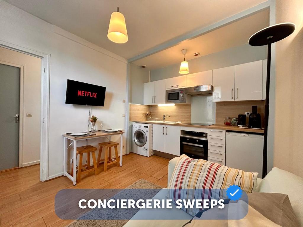 une cuisine avec des armoires blanches et une table dans une pièce dans l'établissement Centre - 80'm du Marché - 2 pers, à Fontainebleau