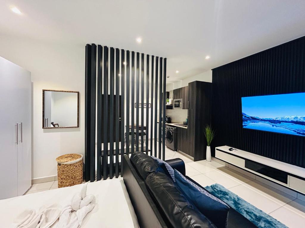a living room with a couch and a flat screen tv at Cozy Abode by Embassy Gardens in Accra