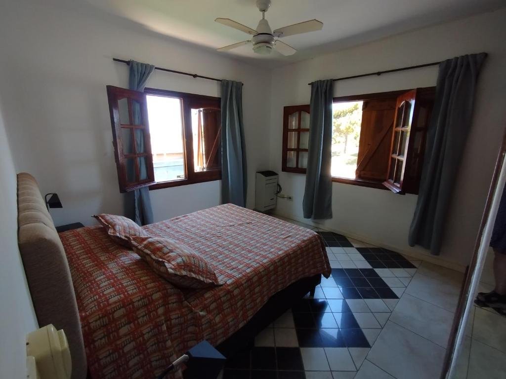 a bedroom with a bed and two windows at Fede Tridente in Pinamar